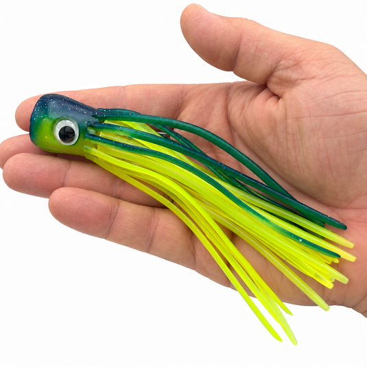 Mold Craft Little Super Chugger 5.5 inch Green/Yellow offshore trolling lure shown in hand for size reference, featuring a green glitter head, large eye, and green-and-chartreuse skirt.