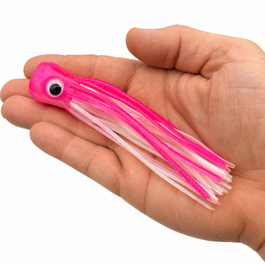 Mold Craft Little Super Chugger 5.5 inch Pink/White offshore trolling lure shown in hand for size reference, featuring a pink glitter head and pink-and-white skirt.