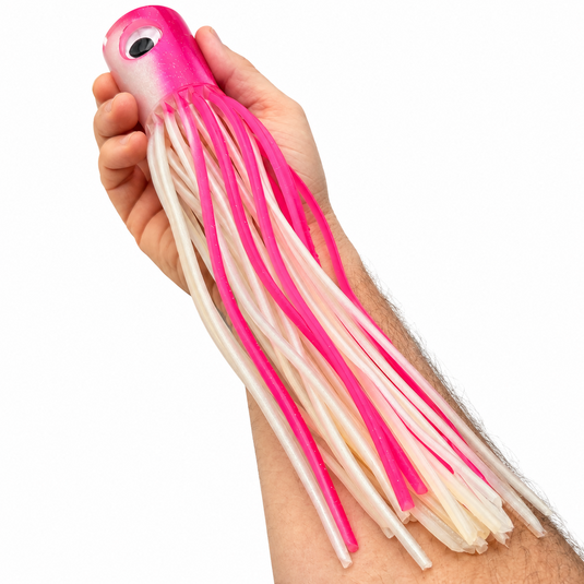 Mold Craft Senior Super Chugger Pink/White offshore trolling lure held in hand for size reference, featuring a bright pink glitter head and pink-and-white skirt.